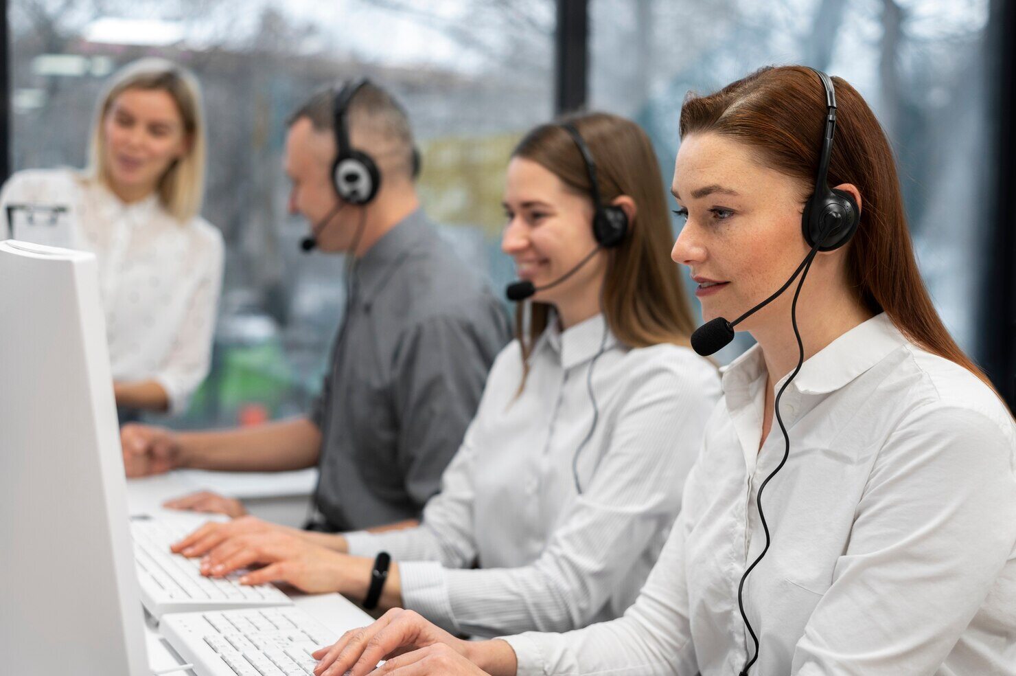 colleagues-working-together-call-center-with-headphones_23-2149256084